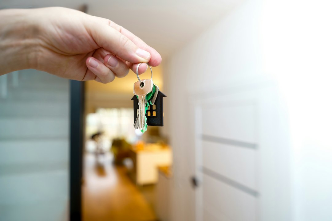 Hand holding a door key inside a home, representing an owner-occupied property
