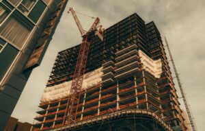 Red construction crane beside a building - Italy development loans for larger schemes